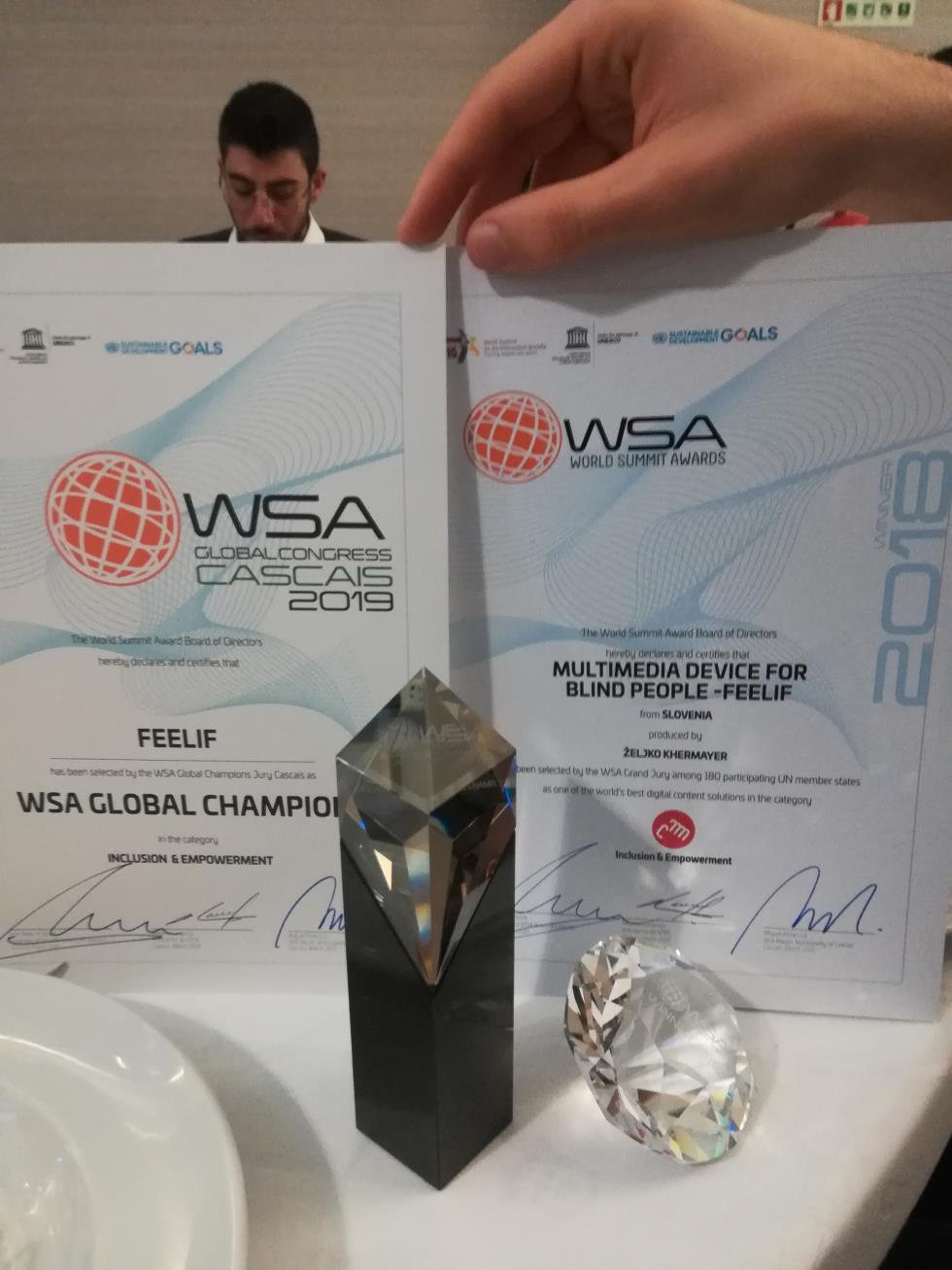 Na sliki sta dve nagradi in dva priznanja, ki jih je Feelif prejel na WSA